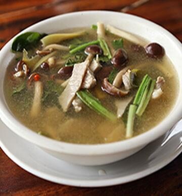 White bowl of Soup with mushrooms, and vegetables