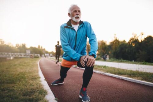 Older man stretching on running track