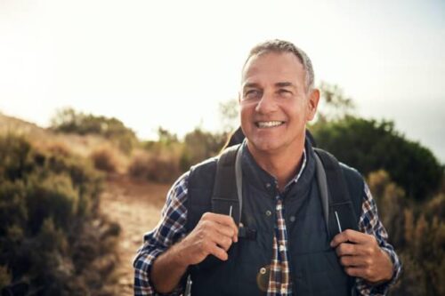 Middle aged smiling man with backpack